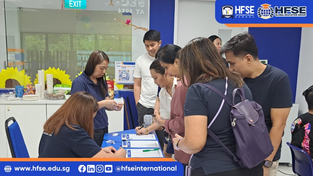 A group of parents lined up at the registration desk.