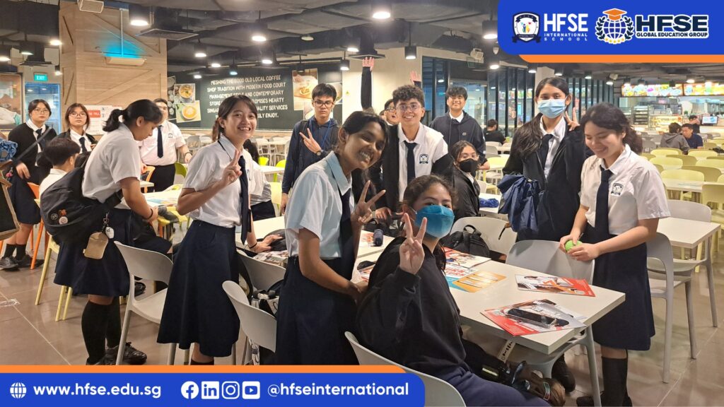 Students smiling and posing for a group photo in a food court setting.