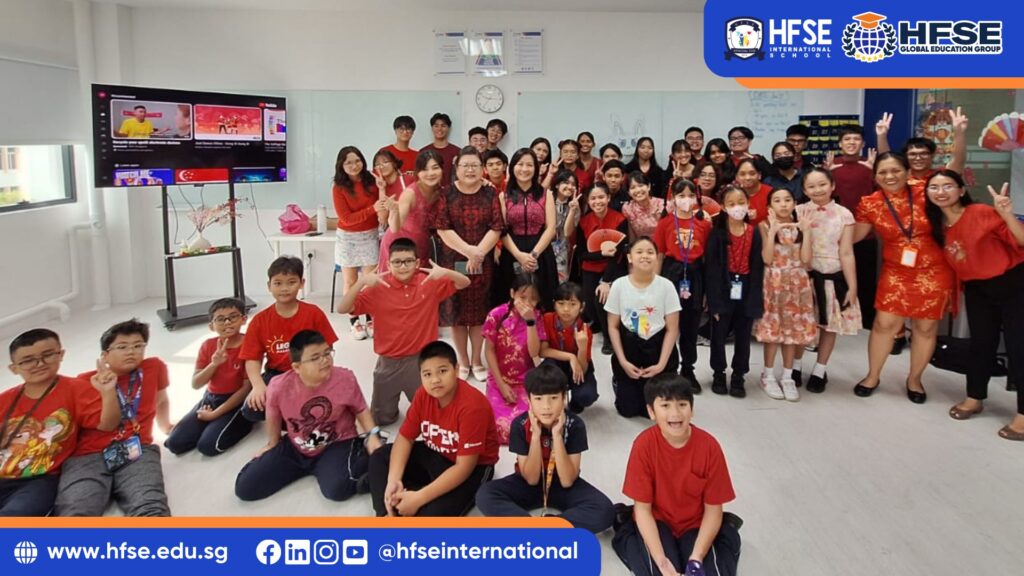 A group of students in Singapore posing for a photo with their teacher in their classroom.