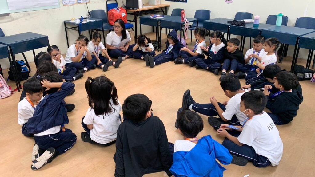 A group of primary school students in Singapore sitting in a circle.